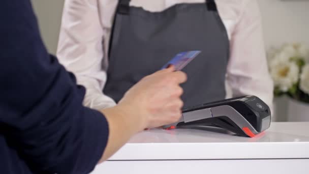 Comprador paga por compras usando um cartão de pagamento. — Vídeo de Stock