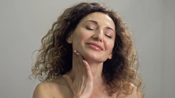 Die schöne Frau mittleren Alters massiert ihren Hals mit leichten Bewegungen. Tägliche Hautpflege. — Stockvideo