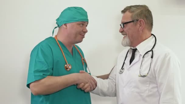 Дружественный разговор между двумя врачами. Взаимоуважение и обмен опытом между различными поколениями. — стоковое видео