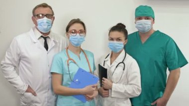 Tıbbi maske takan doktorların toplu portresi. Koronavirüs salgını sırasında maske takma ihtiyacı..