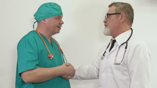 Conversation amicale entre deux médecins. Respect mutuel et échange d'expériences entre les différentes générations. — Video