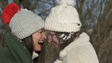 Anne ve yetişkin bir kız ya da iki kız arkadaş birbirlerine bir kış gününün arka planında sevgiyle bakarlar..