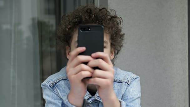 Adolescent qui passe la plupart de son temps avec un téléphone mobile. Dépendance téléphonique. — Video