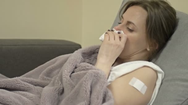 Bijwerkingen van de coronavirusvaccins. Jonge vrouw heeft een hoest, koude rillingen, loopneus. Griepsymptomen, verkoudheid. — Stockvideo