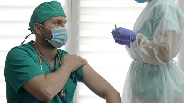 Enfermeira que dá ao médico uma vacina contra o coronavírus. — Vídeo de Stock