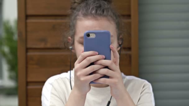 Tonåring flicka som håller telefonen besatt av smartphone sociala medier apps sitter ensam hemma. Teknik missbrukare tonåring spelar mobilspel, sms: ar, tittar på videor på moderna gadget tech. — Stockvideo