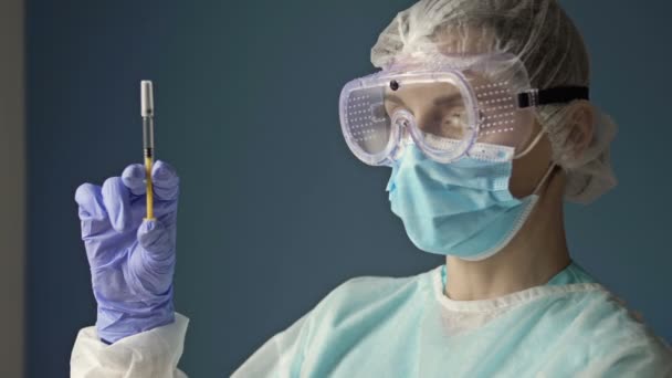 Portret młodej pielęgniarki ze strzykawką gotową do szczepienia pacjenta przeciwko zakażeniu wirusem kovidu 19. — Wideo stockowe