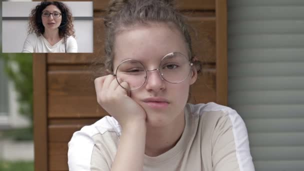 Docent of docent geeft een individuele videoles voor de student. Het meisje verveelt zich, ze gaap. Kenmerken van afstandsonderwijs onder vergrendelingsvoorwaarden. — Stockvideo