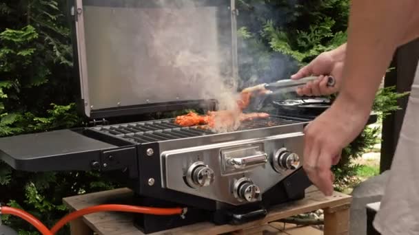 Mão de homem grelhando um pouco de carne na grelha. — Vídeo de Stock