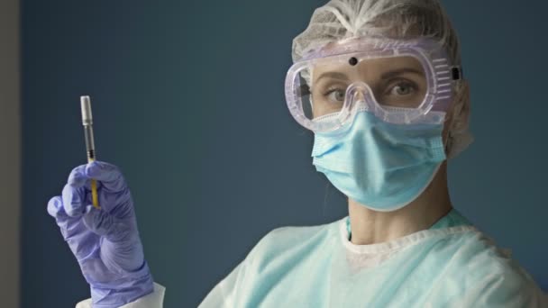 Portret van een jonge verpleegster met een spuit klaar om een patiënt te vaccineren tegen covid 19. — Stockvideo
