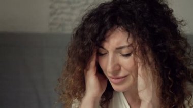 Şiddetli baş ağrısı çeken orta yaşlı bir kadının portresi. Belki de bir şeye çok üzülmüştür..