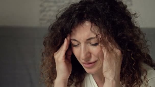 심한 두통으로 고통받는 중년 여성의 모습. 어쩌면 뭔가에 대해 매우 화가나 있을 수도 있고. — 비디오