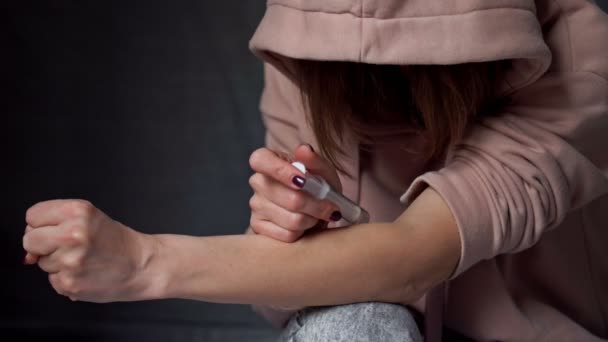 Vrouw die drugs injecteert in haar arm met een spuit. — Stockvideo