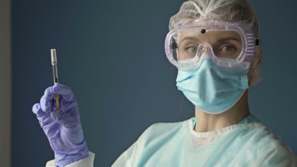 Retrato de uma jovem enfermeira com uma seringa pronta para vacinar um paciente contra o covid 19. — Vídeo de Stock