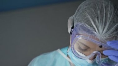 Yorgun bir kadın doktor ya da hemşire portresi. Kadın gözlüğünü çıkarıp maskesini takıyor ve zevkle kahve içiyor. Covid-19 salgını sırasında sağlık çalışanlarının günlük yaşamları acımasızdı..