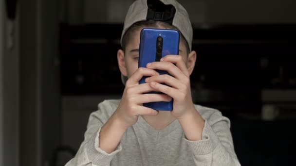Boy gamer, jugando con entusiasmo un juego en un teléfono móvil. Adicción moderna. — Vídeos de Stock