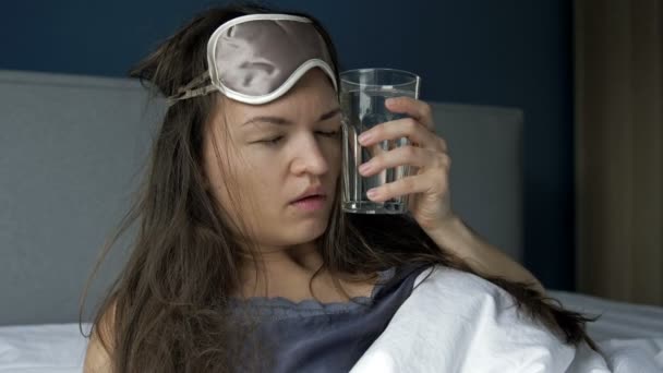 Σκληρή αφύπνιση μιας γυναίκας μετά από υπερβολική κατανάλωση αλκοόλ. Πονοκέφαλος, ξηροστομία, ναυτία. Σύνδρομο μέθης. — Αρχείο Βίντεο