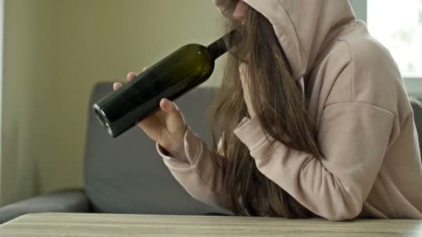 Een onverzorgde vrouw drinkt wijn uit een fles alleen. Het sociale probleem van het vrouwelijke alcoholisme. — Stockvideo