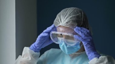 Yorgun bir kadın doktor ya da hemşire portresi. Kadın gözlüğünü ve maskesini çıkardı ve rahat bir nefes aldı. Salgın Covid-19.