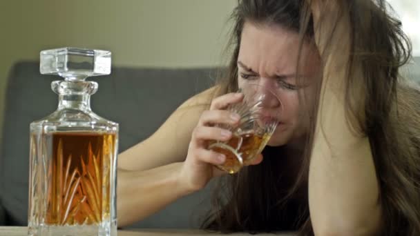 Жінка плаче, п'є алкоголь сама. Спроба зняти стрес. Негативні емоції, поганий настрій через неулюблену роботу, особисті проблеми, розставання з коханцем, обман . — стокове відео