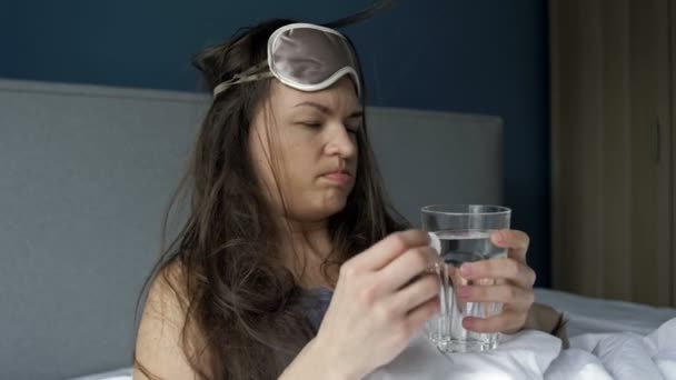 Ciężkie przebudzenie kobiety po nadmiernym spożyciu alkoholu. Ból głowy, suchość w ustach, nudności. Zespół kaca. — Wideo stockowe