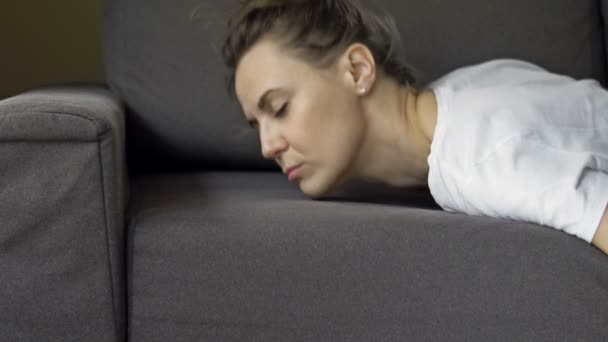 Yorgun bir kadın, yorgun, kanepede uyuyakalıyor. İşçilik. Fazla mesai. — Stok video