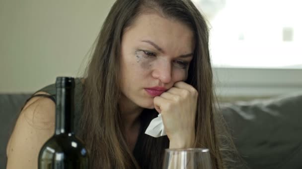 Une jeune femme déprimée qui pleure - victime de violence conjugale ou d'abus - tente de soulager sa souffrance avec de l'alcool. Violence domestique. — Video