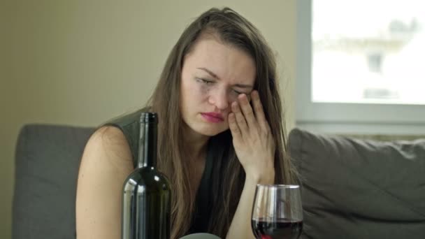 Плачущая женщина пьет алкоголь одна. Попытка снять стресс. Отрицательные эмоции, плохое настроение из-за нелюбимой работы, личные проблемы, расставание с любовником, обман. — стоковое видео
