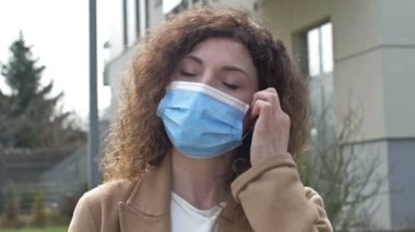 Maske modunun iptali. Orta yaşlı bir kadın sokakta koruyucu maskesini çıkarıp rahatça iç çekiyor. Covid-19 salgını azalıyor..