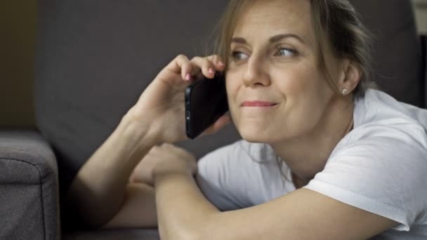 Portrait of a beautiful middle aged woman talking on a cell phone. There is a happy smile on the womans face. She looks like shes in love. — Stock Video