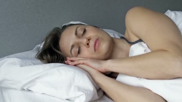 Zmęczona kobieta nie może spać. Jakiekolwiek dźwięki ją irytują. Bezsenność. — Wideo stockowe