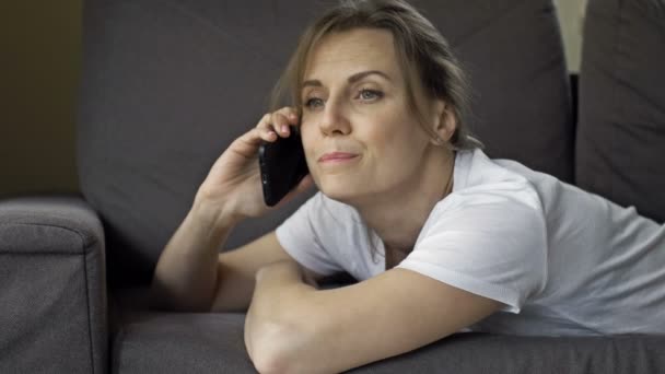 Portrait of a beautiful middle-aged woman talking on a cell phone. The woman looks tired. — Stock Video