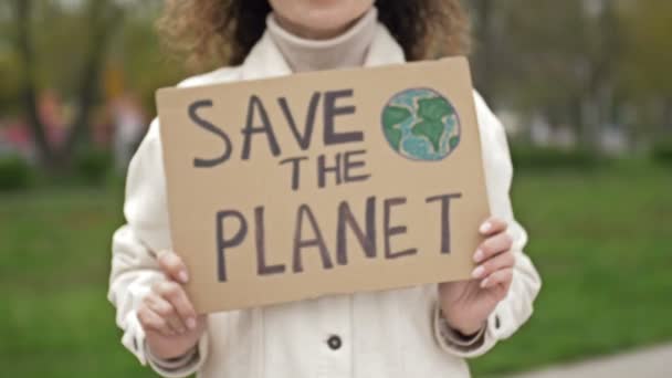 Mulher com um cartaz SALVEM O PLANETA. Contribuição viável para a luta contra a poluição global da natureza. Piquete único. — Vídeo de Stock