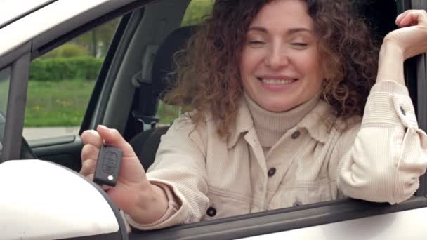 Erfolgreiche schöne glückliche Frau im neuen Auto mit Schlüsseln. — Stockvideo