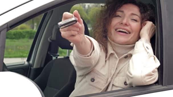 Succesvolle mooie gelukkige vrouw in de nieuwe auto met sleutels. — Stockvideo