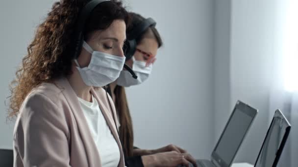 Operadores de call center com máscaras médicas. Trabalho de escritório durante a epidemia de coronavírus. — Vídeo de Stock