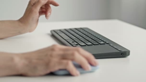 Manos femeninas escribiendo en el teclado y sosteniendo el ratón de la computadora sobre fondo claro — Vídeos de Stock