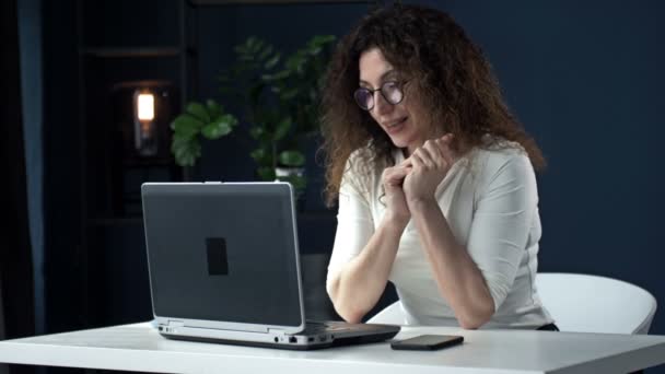 Emploi à distance pendant le coronavirus. Jeune femme au bureau. Femme d'affaires souriante utilisant un ordinateur portable lors d'un appel vidéo. — Video