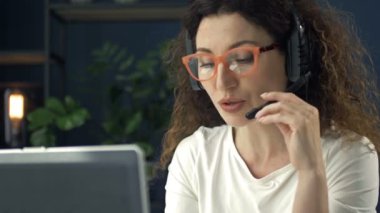 Güzel orta yaşlı bir kadın video aracılığıyla biriyle iletişim kurarken eğleniyor..