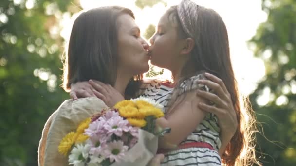 Little girl gives flowers to her mother. Lovely family together. Summer day. Family portrait. Happy motherhood. Enjoy nature. Mothers Day. — Stock Video