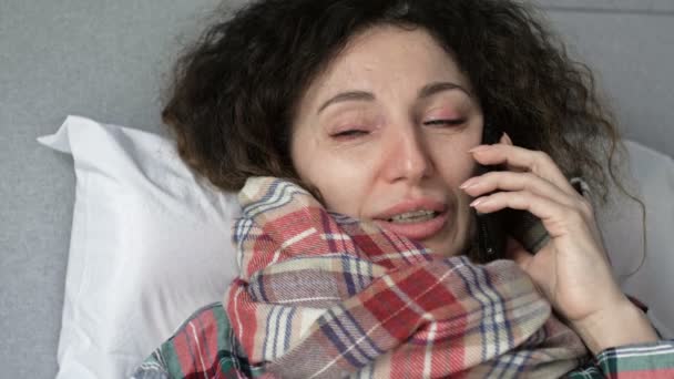 Retrato de una mujer enferma con síntomas de gripe, resfriado o coronavirus que habla por teléfono celular. — Vídeos de Stock