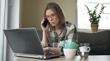 Uzaktan çalışan iş kadını iş günü sonunda çok yoruldu. Masada birkaç boş çay ve kahve var. Fazla çalışma kavramı.