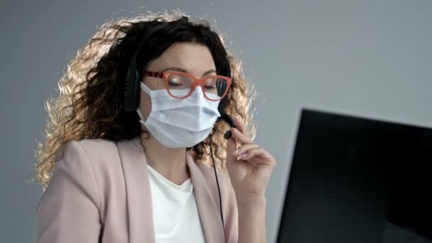 Operatore di call center in maschera medica. Lavoro d'ufficio durante l'epidemia di coronavirus. — Video Stock