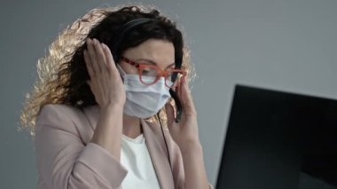 Tıbbi maskeli çağrı merkezi operatörü. Coronavirüs salgını sırasında ofis işi..