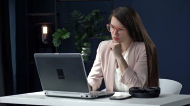 Ofisteki yorgun genç kadın gece geç saatlere kadar çalışıyor. Akşam geç saatlerde çok çalışan yorgun iş kadınının portresi..