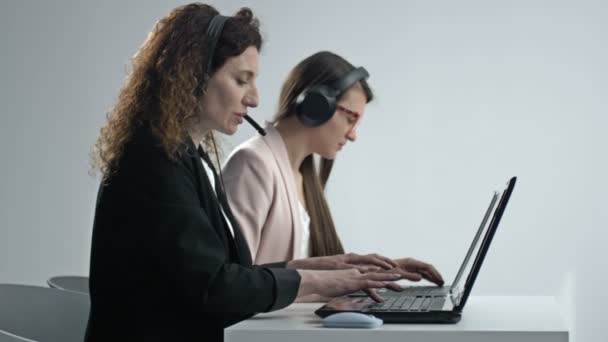 配备耳机的客户支持代理或呼叫中心在台式计算机上工作，同时支持客户打电话。经营者服务企业代表概念. — 图库视频影像