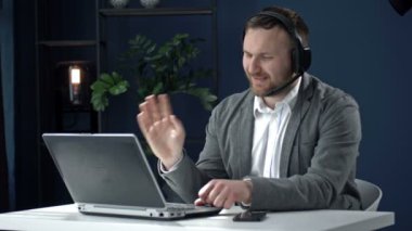 İş adamı iş ortağıyla dostça iletişim kurar, aktif olarak el kol hareketi yapar. Uzak çalışma.