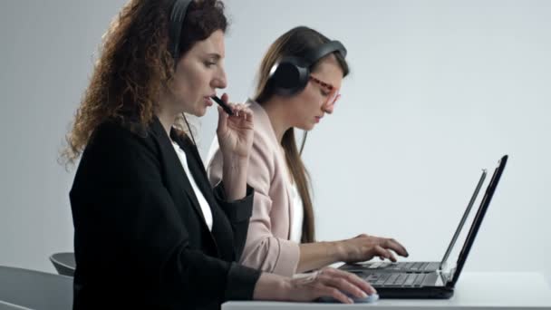 L'agente dell'assistenza clienti o il call center con cuffie funziona sul computer desktop mentre supporta il cliente al telefono. Concetto di rappresentante aziendale del servizio operatore. — Video Stock