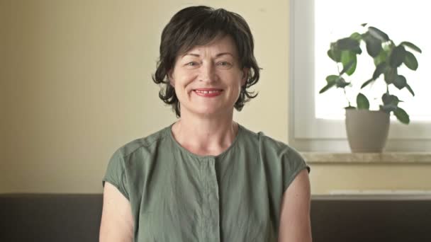 Portret van een positieve vrouw die aan kanker lijdt. Een vrouw neemt haar pruik af van haar kale hoofd na chemotherapie en toont met een gebaar ALLES WELL ZIJN. — Stockvideo