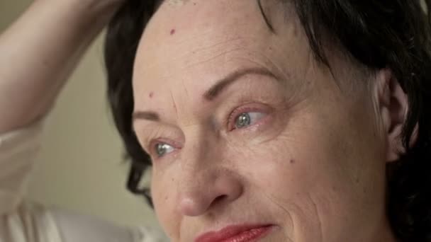 Le visage d'une femme atteinte d'un cancer. Elle retire sa perruque de sa tête chauve. Alopécie résultant d'une chimiothérapie. Il y a des larmes dans ses yeux de douleur, de peur et de désespoir. Gros plan. — Video